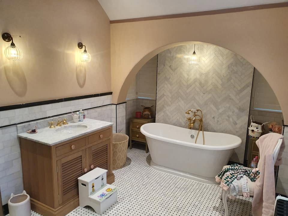 Finished bathroom renovation with freestanding bath, marble vanity and brass fittings